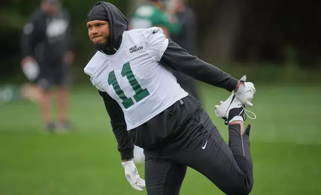 New York Jets linebacker Jermaine Johnson II (11) stretch during NFL football practice at an NFL football practice at The Grove in Watford, England, Friday, Oct. 10, 2025. (AP Photo/Kin Cheung)