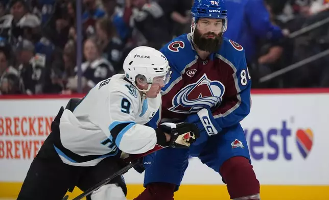 Utah Mammoth right wing Clayton Keller, left, drives past Colorado Avalanche defenseman Brent Burns, right, in the second period of an NHL hockey game Thursday, Oct. 9, 2025, in Denver. (AP Photo/David Zalubowski)
