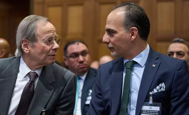 Palestinian Ambassadors to the United Nations Ammar Hijazi, right, waits for the reading of the advisory opinion of the International Court of Justice on what Israel must do to ensure humanitarian aid reaches Palestinians in Gaza and the occupied West Bank, in The Hague, Netherlands, Wednesday, Oct. 22, 2025. (AP Photo/Peter Dejong)