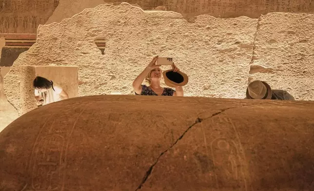 Marzena A. Ozarek, President of mummy research center, films the sarcophagus of King Amenhotep III, who ruled ancient Egypt between 1390 B.C. and 1350 B.C., at his tomb in the Valley of Kings in the southern city of Luxor, Egypt, Saturday, Oct. 4, 2025, as it opened to visitors for the first time in more than two decades. (AP Photo/Amr Nabil)