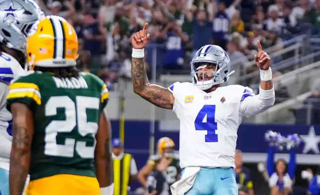 Dallas Cowboys quarterback Dak Prescott (4) celebrates in front of Green Bay Packers' Keisean Nixon (25) after Javonte Williams rushed for a touchdown in the second half of an NFL football game Sunday, Sept. 28, 2025, in Arlington, Texas. (AP Photo/Jeffrey McWhorter)