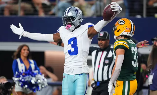 Dallas Cowboys' George Pickens (3) celebrates in front of Green Bay Packers' Evan Williams (33) after Pickens caught a pass late in the first first half of an NFL football game Sunday, Sept. 28, 2025, in Arlington, Texas. (AP Photo/Julio Cortez)