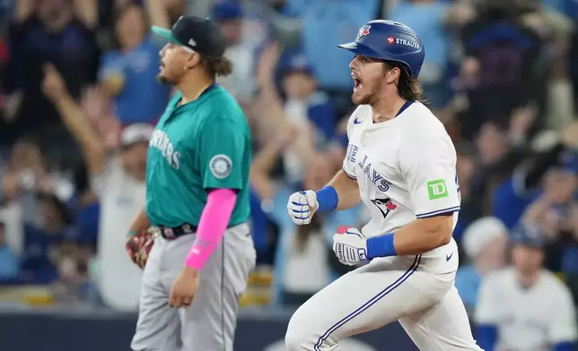 Toronto Blue Jays' Addison Barger, right, rounds the bases after hitting a two-run home run against the Seattle Mariners during the third inning in Game 6 of baseball's American League Championship Series in Toronto, Sunday, Oct. 19, 2025. (Nathan Denette/The Canadian Press via AP)