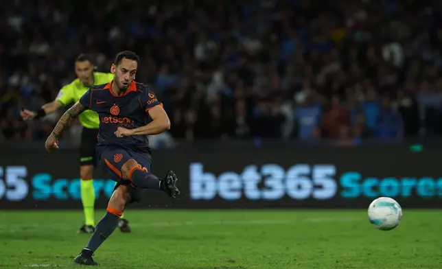 Inter Milan's Hakan Calhanoglu scores their side's first goal of the game during the Italian Serie A soccer match between Napoli and Inter Milan, in Naples, Italy, Saturday, Oct. 25, 2025. (Alessandro Garofalo/LaPresse via AP)