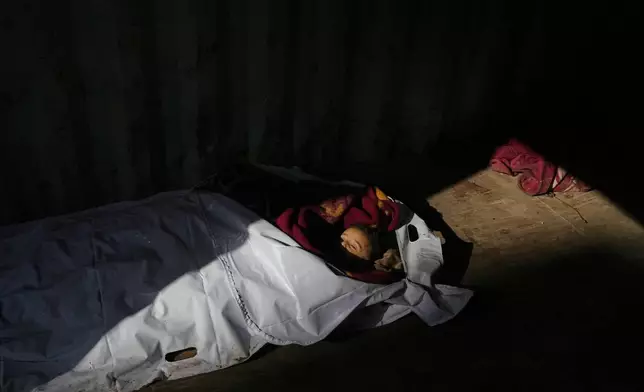 The body of 4-year-old Palestinian, Ahmed Weshah lies next to that of his mother Afaf Abu Jahjouh, 28, who were both killed in an Israeli military strike on Sunday, before their funeral at Awda Hospital, in Nuseirat, in the central Gaza Strip, Monday, Oct. 20, 2025. (AP Photo/Abdel Kareem Hana)