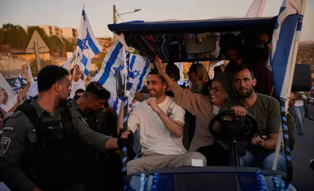Freed hostage, Avinatan Or, center, who was recently released from Hamas captivity in Gaza, is welcomed as he return from the hospital to his home in the West Bank Jewish settlement of Shilo, Tuesday, Oct. 21, 2025. (AP Photo/Ohad Zwigenberg)