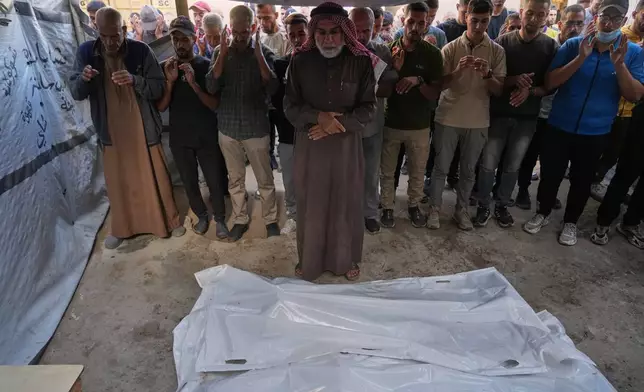 Palestinians pray over the bodies of people who were killed in an Israeli military strike on Sunday, during their funeral at Awda Hospital, in Nuseirat, in the central Gaza Strip, Monday, Oct. 20, 2025. (AP Photo/Abdel Kareem Hana)