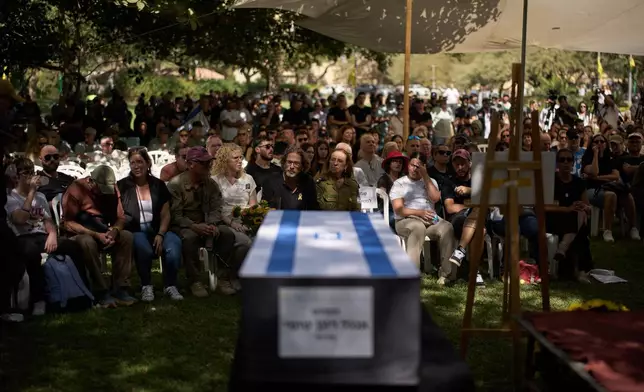 Relatives and friends attend the funeral of slain hostage Ronen Engel after his body was returned from Gaza as part of a ceasefire agreement between Israel and Hamas at Kibbutz Nir Oz, southern Israel, Tuesday, Oct. 21, 2025. (AP Photo/Leo Correa)