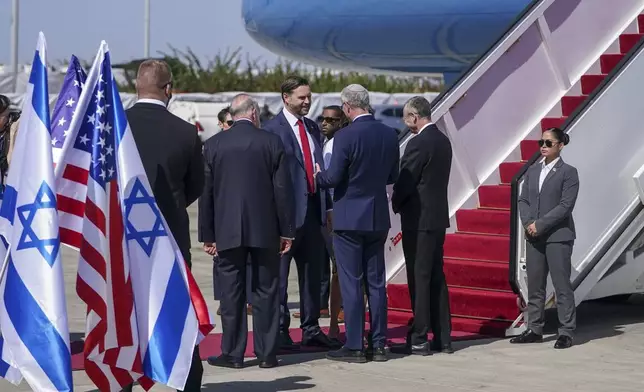 Vice President J.D. Vance, center, is welcomed by Israeli ambassador to the U.S. Yechiel Leiter and U.S. ambassador to Israel Mike Huckabee, back to camera, upon his arrival at Ben Gurion airport in Tel Aviv, Israel, Monday, Oct. 21, 2025. (Nathan Howard/Pool Photo via AP)