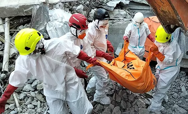 In this photo released by the Indonesian National Search and Rescue Agency (BASARNAS) on Monday, October. 6, 2025, rescuers remove the body of a victim from the rubble of a collapsed building at an Islamic boarding school in Sidoarjo, East Java, Indonesia.(BASARNAS via AP)
