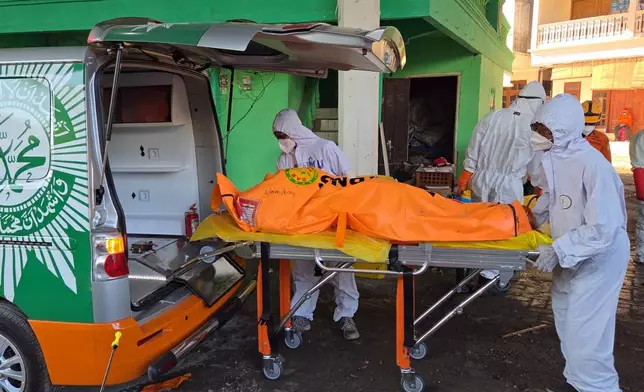 In this photo released by the Indonesian National Search and Rescue Agency (BASARNAS) on Monday, October. 6, 2025, rescuers put the body of a victim recovered from the rubble of a collapsed building at an Islamic boarding school into an ambulance in Sidoarjo, East Java, Indonesia.(BASARNAS via AP)