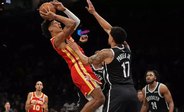 Atlanta Hawks' Jalen Johnson shoots over Brooklyn Nets' Michael Porter Jr., right, during the first half of an NBA basketball game Wednesday, Oct. 29, 2025, at Barclays Center in New York. (AP Photo/Frank Franklin II)