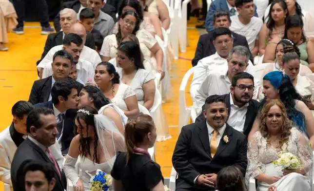 Couples attend a group ceremony organized by the Civil Registry to legally formalize their unions in in Asuncion, Paraguay, Saturday, Oct. 4, 2025. (AP Photo/Jorge Saenz)