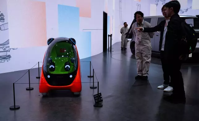 Members of media and guests look at the Toyota's Kids mobi during the press day of the Japan Mobility Show, in Tokyo, Thursday, Oct. 30, 2025. (AP Photo/Louise Delmotte)