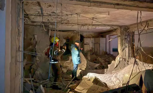 This photo released by Moscow Region Governor Andrei Vorobyev official telegram channel shows investigators working in the damaged multi-storey apartment building hit by a Ukrainian drone in Krasnogorsk, just outside Moscow, Russia, on Friday, Oct. 24, 2025. (Moscow Region Governor Andrei Vorobyev official telegram channel via AP)