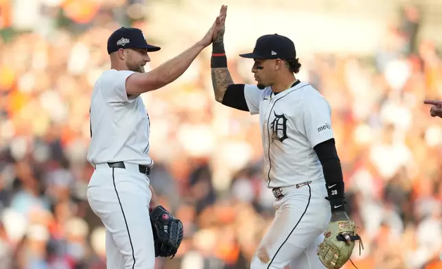 Detroit Tigers' Will Vest and Javier Báez, right, celebrate a victory over the Seattle Mariners in Game 4 of baseball's American League Division Series Wednesday, Oct. 8, 2025, in Detroit. (AP Photo/Paul Sancya)