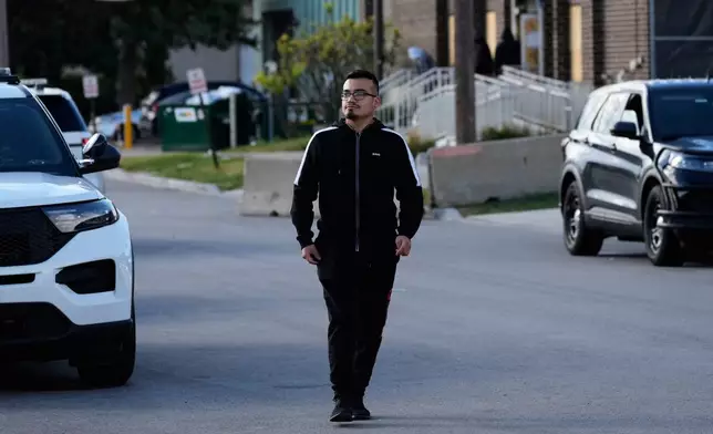 Delfino Ropez walks along the street after handing prescription medication over to a security guard for his uncle who was detained outside an ICE processing facility in the Chicago suburb of Broadview, Ill., Tuesday, Oct. 21, 2025. (AP Photo/Nam Y. Huh)