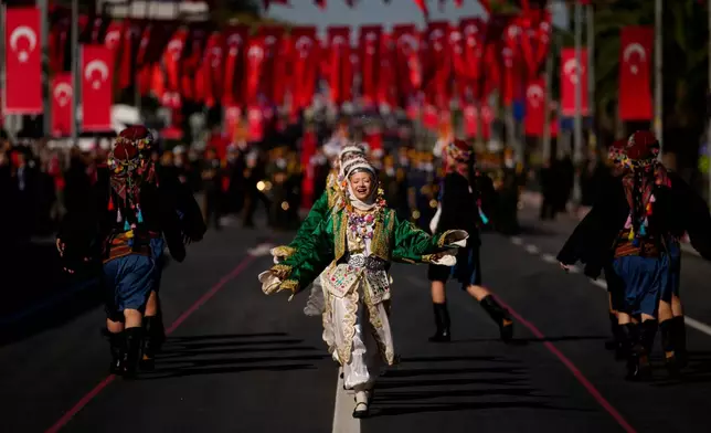 Young women wearing folk traditional costumes parade as part of celebrations marking the 102nd anniversary of the creation of the modern Turkish Republic, in Istanbul, Turkey, Wednesday, Oct. 29, 2025. (AP Photo/Emrah Gurel)