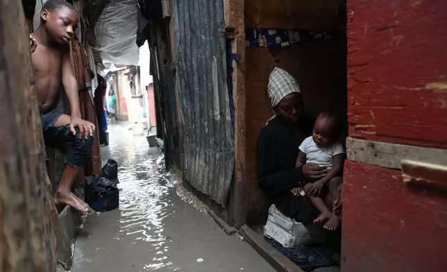 People stay inside a shelter for families displaced by gang violence, flooded by rain brought by Hurricane Melissa, in Port-au-Prince, Haiti, Wednesday, Oct. 29, 2025. (AP Photo/Odelyn Joseph)