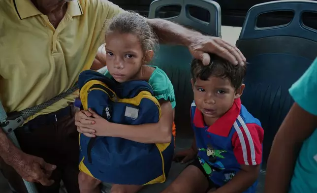 Children are evacuated on a bus before the arrival of Hurricane Melissa in Canizo, a community in Santiago de Cuba, Tuesday, Oct. 28, 2025. (AP Photo/Ramón Espinosa)