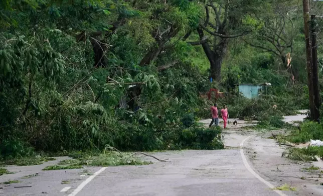 People walk along a road after Hurricane Melissa passed through Spurr Tree, Jamaica, Wednesday, Oct. 29, 2025. (AP Photo/Matias Delacroix),
