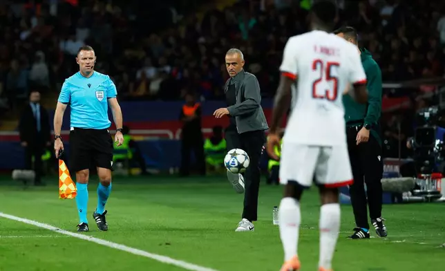 PSG's head coach Luis Enrique, center, kicks the ball during the Champions League opening phase soccer match between Barcelona and Paris Saint-Germain at the Lluis Companys Olympic Stadium in Barcelona, Spain, Wednesday, Oct. 1, 2025. (AP Photo/Joan Monfort)