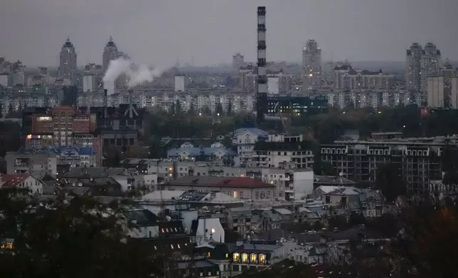 Smoke bellows in the background at dusk in Kyiv, Ukraine, Tuesday, Oct. 21, 2025. (AP Photo/Julia Demaree Nikhinson)