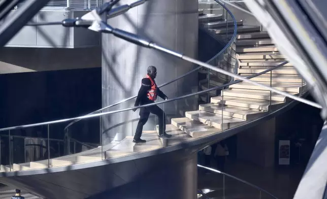 A private member of the security claims up the stairs in the Louvre museum, Thursday, Oct. 30, 2025 in Paris. (AP Photo/Emma Da Silva)