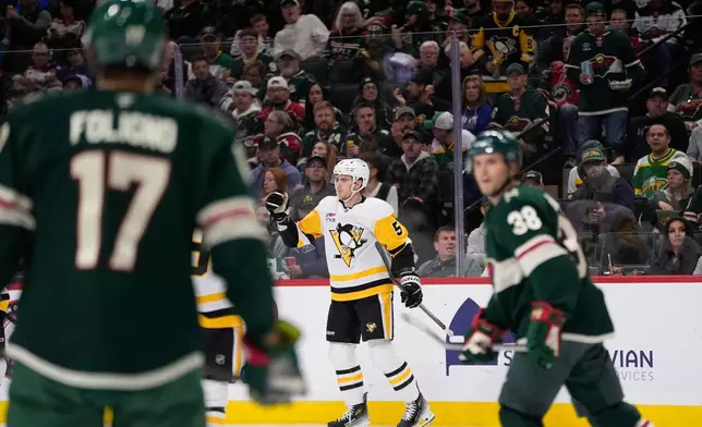Pittsburgh Penguins defenseman Ryan Shea (5), middle, celebrates near Minnesota Wild left wing Marcus Foligno (17) and right wing Ryan Hartman (38) after scoring a goal during the second period of an NHL hockey game, Thursday, Oct. 30, 2025, in St. Paul, Minn. (AP Photo/Abbie Parr)