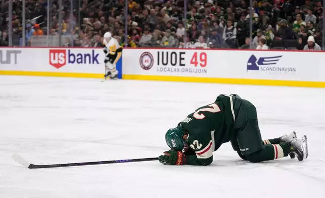 Minnesota Wild right wing Danila Yurov (22) lays on the ground after sustaining an injury during the second period of an NHL hockey game against the Pittsburgh Penguins, Thursday, Oct. 30, 2025, in St. Paul, Minn. (AP Photo/Abbie Parr)