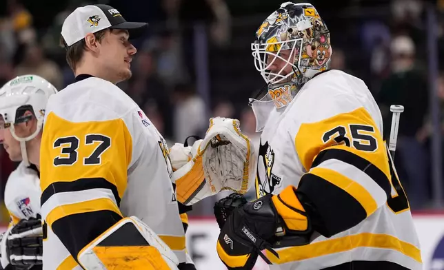 Pittsburgh Penguins goaltender Tristan Jarry (35) hugs Arturs Silovs (37) after an NHL hockey game against the Minnesota Wild, Thursday, Oct. 30, 2025, in St. Paul, Minn. (AP Photo/Abbie Parr)