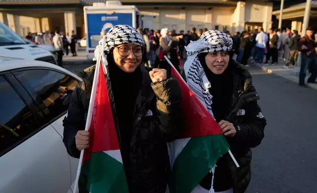 Malaysian sisters Heliza and Hazwani Helmi hold Palestinian flags after arriving in Istanbul, Turkey, with 137 activists from the Global Sumud Flotilla, Saturday, Oct. 4, 2025. (AP Photo/Khalil Hamra)