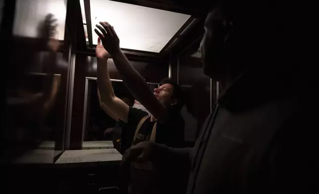 Konstantinos Pantoudis tries to catch a bee in an elevator during a late-night hive transfer in the Ilioupoli suburb of Athens, Greece, May 6, 2025. (AP Photo/Michael Varaklas)
