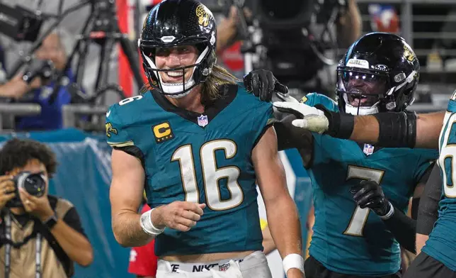 Jacksonville Jaguars quarterback Trevor Lawrence (16) celebrates with teammates after scoring a touchdown during the second half of an NFL football game against the Kansas City Chiefs, Monday, Oct. 6, 2025, in Jacksonville, Fla. (AP Photo/Phelan M. Ebenhack)
