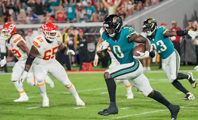 Jacksonville Jaguars linebacker Devin Lloyd (0) runs the ball 99 yards for a touchdown after intercepting a pass during the second half of an NFL football game against the Kansas City Chiefs, Monday, Oct. 6, 2025, in Jacksonville, Fla. (AP Photo/John Raoux)