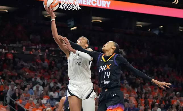 Las Vegas Aces center A'ja Wilson (22) gets fouled by Phoenix Mercury forward DeWanna Bonner during the first half of Game 3 of the WNBA basketball finals, Wednesday, Oct. 8, 2025, in Phoenix. (AP Photo/Rick Scuteri)