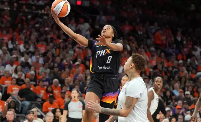 Phoenix Mercury guard Monique Akoa Makani (8) shoots over Las Vegas Aces forward Kierstan Bell during the second half of Game 3 of the WNBA basketball finals, Wednesday, Oct. 8, 2025, in Phoenix. (AP Photo/Rick Scuteri)