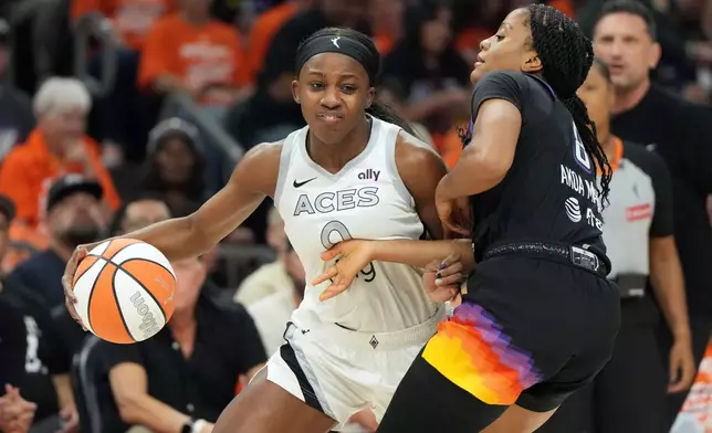 Las Vegas Aces guard Jackie Young drives on Phoenix Mercury guard Monique Akoa Makani (8) during the first half of Game 3 of the WNBA basketball finals, Wednesday, Oct. 8, 2025, in Phoenix. (AP Photo/Rick Scuteri)