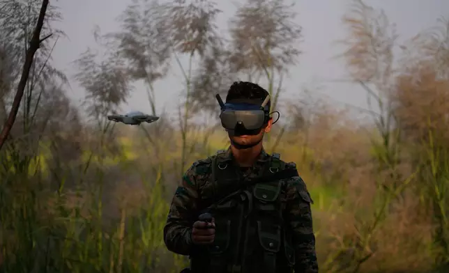 An Indian army soldier controls a drone during tactical drills along the heavily militarized Line of Control (LoC) dividing the Kashmir region between India and Pakistan, in the Akhnoor sector, approximately 66 kilometers (41 miles) from Jammu, India, Thursday, Oct. 16, 2025. (AP Photo/Channi Anand)