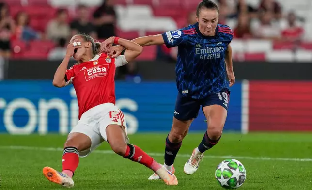 Arsenal's Caitlin Foord, right, challenges for the ball with Benfica's Lucia Alves during the women's Champions League opening phase soccer match between SL Benfica and Arsenal at the Luz Stadium, in Lisbon, Portugal, Thursday, Oct. 16, 2025. (AP Photo/Armando Franca)