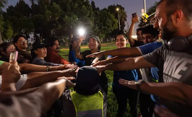 Iris Delgado, center, founder of the Huntington Park Run Club, leads a huddle after their run in Huntington Park, Calif., Sept. 24, 2025. (AP Photo/Jae C. Hong)