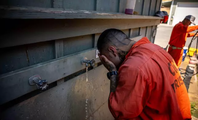 Damien Rubalcava washes his face after work at the Pine Grove Youth Conservation Camp, July 14, 2025, in Red Corral, Calif. (AP Photo/Ethan Swope)