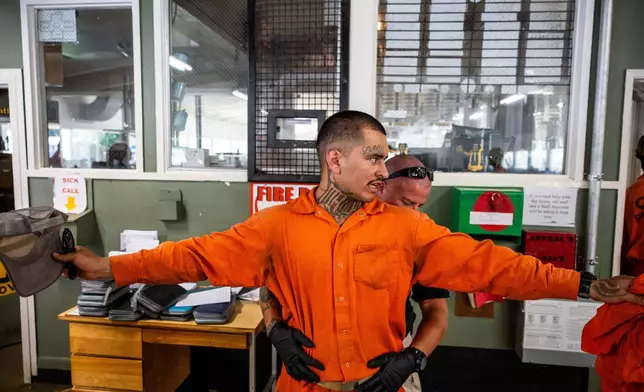 Damien Rubalcava, left, is patted down after work at the Pine Grove Youth Conservation Camp, July 14, 2025, in Red Corral, Calif. (AP Photo/Ethan Swope)