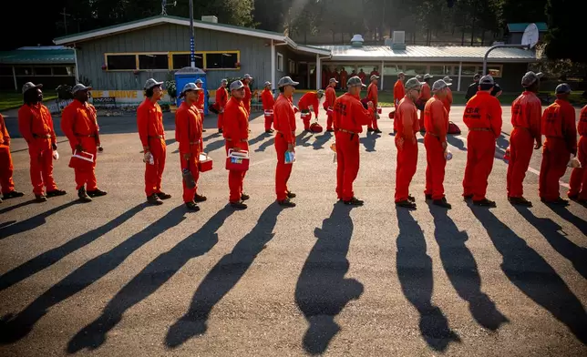 Participants in the Youth Offender Program Camp Pilot Program line up before work at the Pine Grove Youth Conservation Camp, July 14, 2025, in Red Corral, Calif. (AP Photo/Ethan Swope)