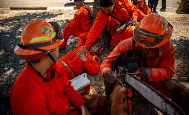 Pine Grove Youth Conservation Camp inmates take a lunch break, July 14, 2025, near Ione, Calif. (AP Photo/Ethan Swope)
