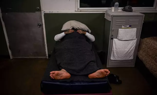 An inmate rests at the Pine Grove Youth Conservation Camp, July 14, 2025, in Red Corral, Calif. (AP Photo/Ethan Swope)