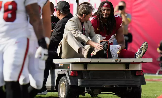 San Francisco 49ers middle linebacker Fred Warner, right, is carted off the field during the first half of an NFL football game against the Tampa Bay Buccaneers in Tampa, Fla., Sunday, Oct. 12, 2025. (AP Photo/Chris O'Meara)