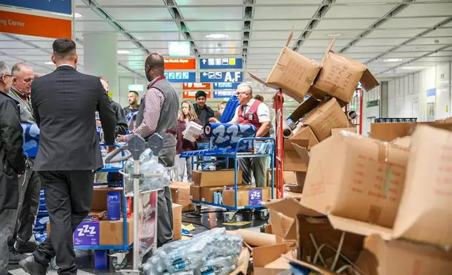 Drinks and snacks are distributed after possible drone sightings closed Munich Airport, Saturday, Oct. 4, 2025, in Munich, Germany. (Enrique Kaczor/onw-images/dpa via AP)