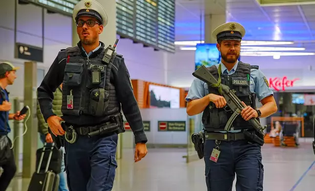 Police officers patrol Munich Airport after the airport shut down operations due to possible new drone sightings Friday, Oct. 3, 2025, in Munich. (Enrique Kaczor/dpa via AP)
