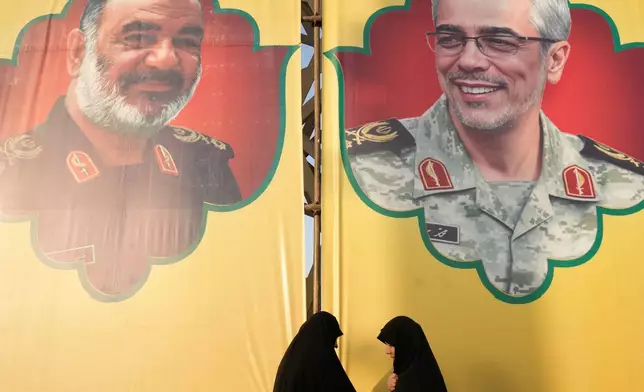 Women talk in front of the banners showing portraits of the late chief of the general staff of Iran's armed forces, Gen. Mohammad Hossein Bagheri, right, and the late commander of Revolutionary Guard Gen. Hossein Salami, who were killed in Israeli strike in June, during a commemoration marking the first death anniversary of Hezbollah leaders Hassan Nasrallah and Hashem Safieddine, who were killed in Israeli airstrikes in Beirut, in Tehran, Iran, Thursday, Oct. 2, 2025. (AP Photo/Vahid Salemi)